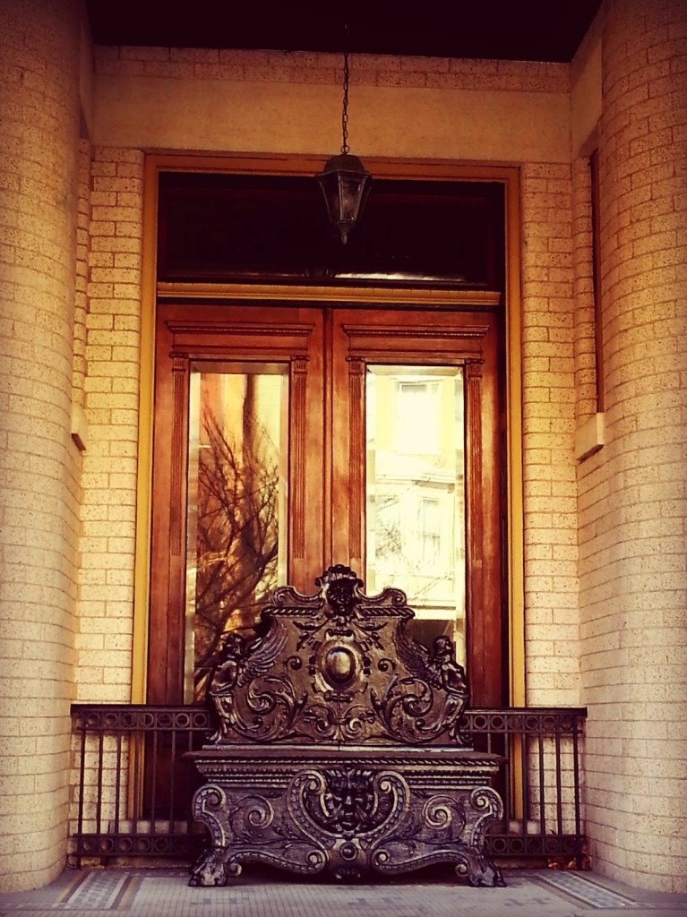 An ornamental chair that looks like a throne in front of doors