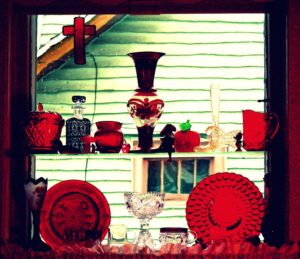 Red glasses and ornaments displayed at a window